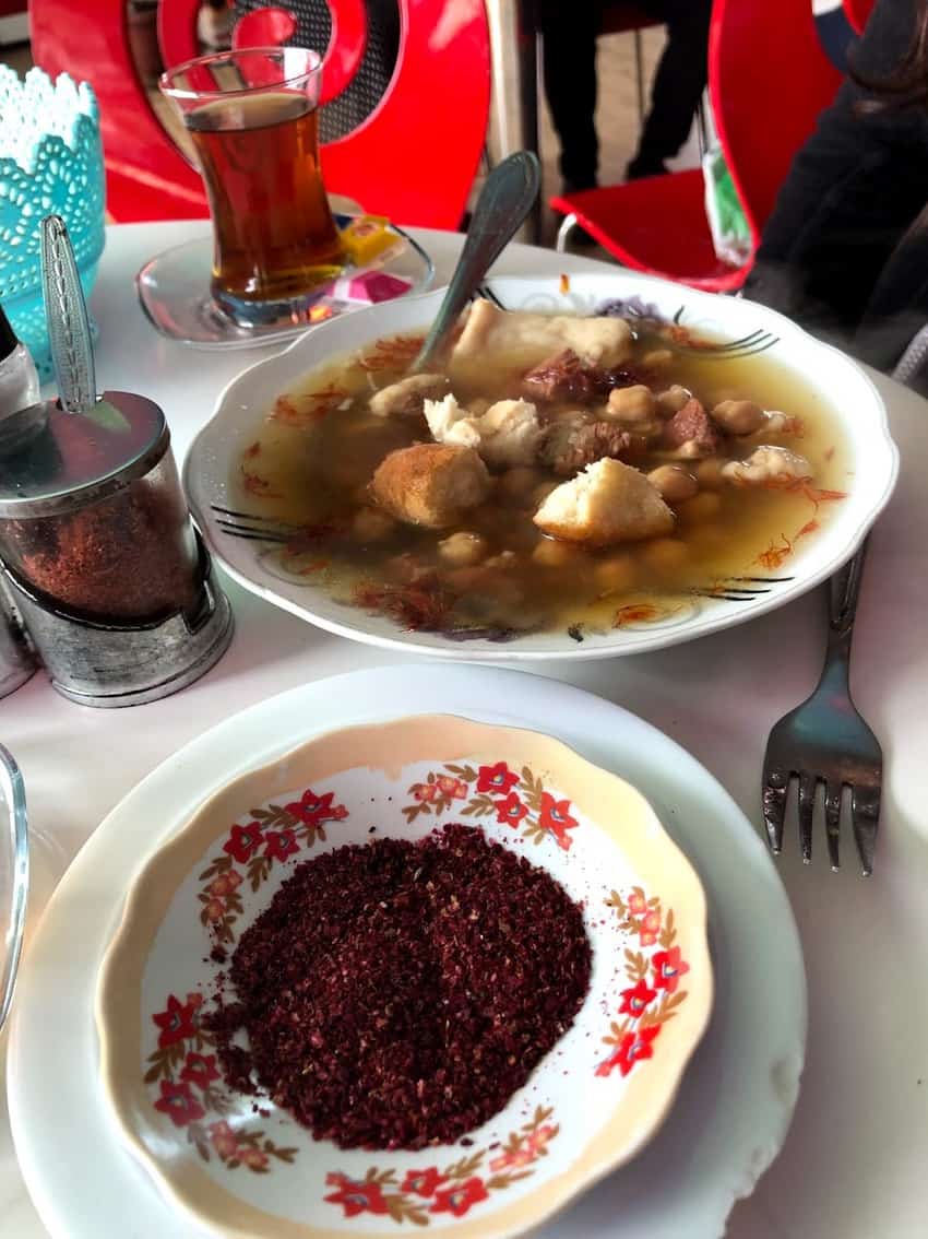 The famous Sheki Piti dish served with a side of spices and bread.
