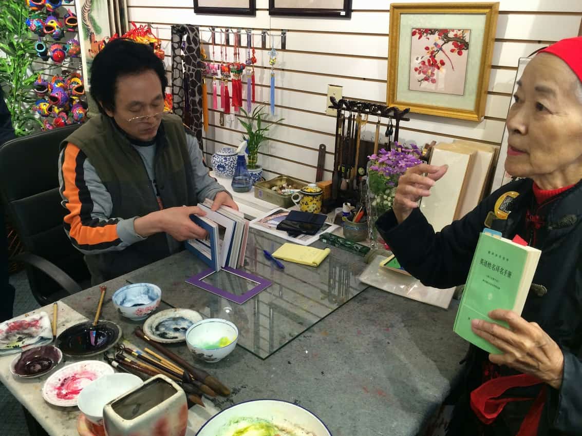 Luo Wen Jing shows us his calligraphy skills in his Chinatown shop.
