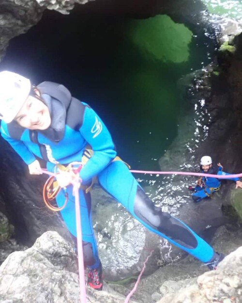 smiling while abseiling into canyon