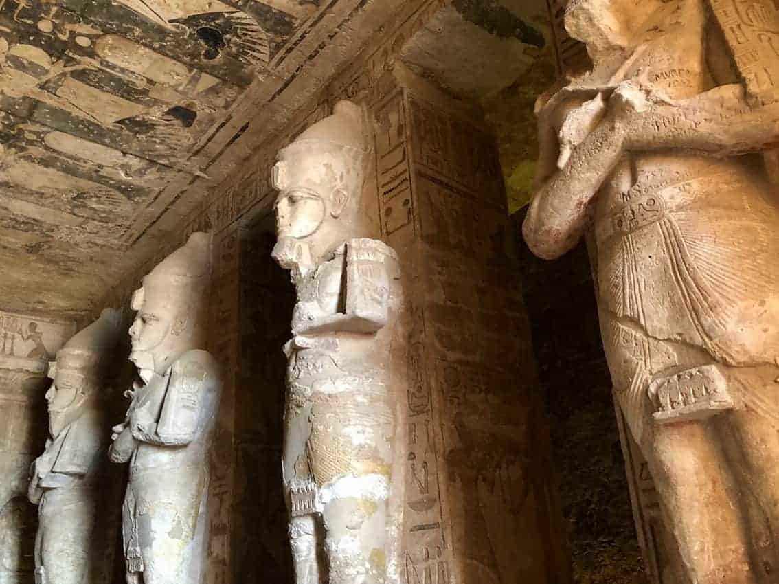 The Osiris Statues carrying crook and flail in the hypostyle hall. The southern pillars wear the Upper Egypt crown, while the northern ones wear the double crown of Upper and Lower Egypt. 