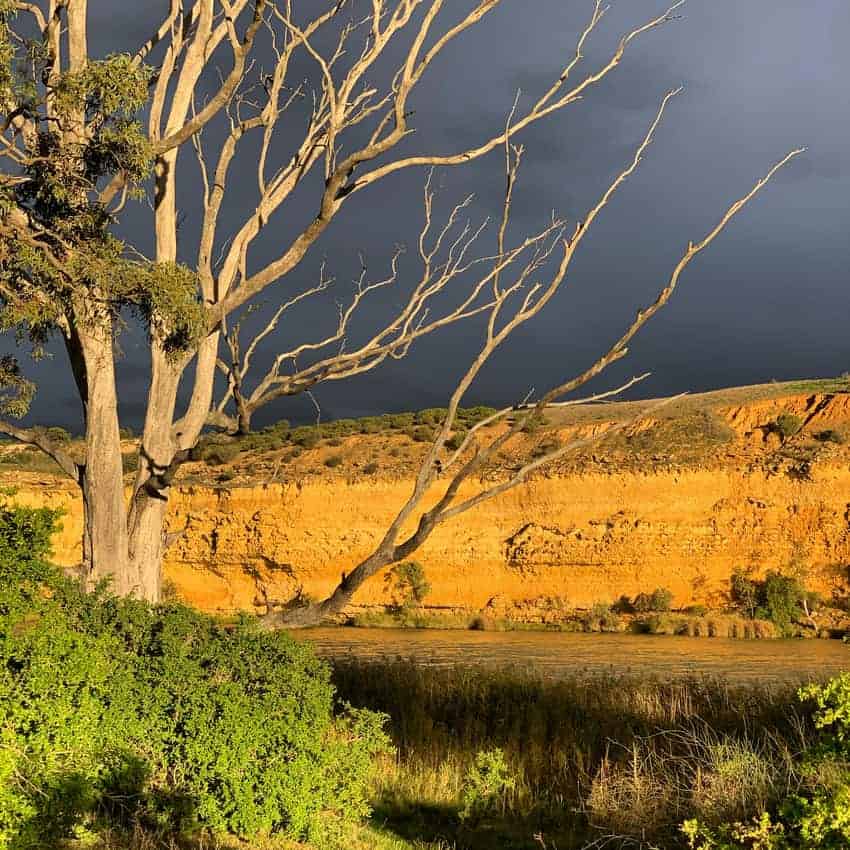 Dark clouds highlight cliffs like Honeycomb.