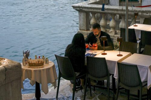 couple dining under a bridge in Venice