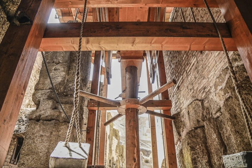 A replica elevator shows the wheel and counterweights that lift the animals to the Colosseum floor.