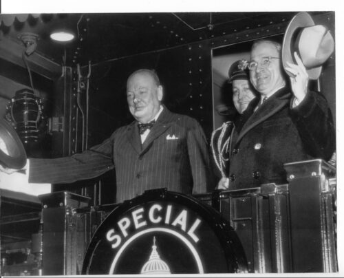 Churchill Truman Major General Harry Vaughan back wave to crowds from Presidential train car en route to Fulton Courtesy of Americas National Churchill Museum