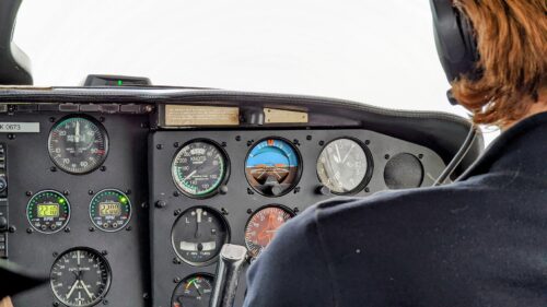 Close-up of flight instruments and co-pilot from the back of the small plane