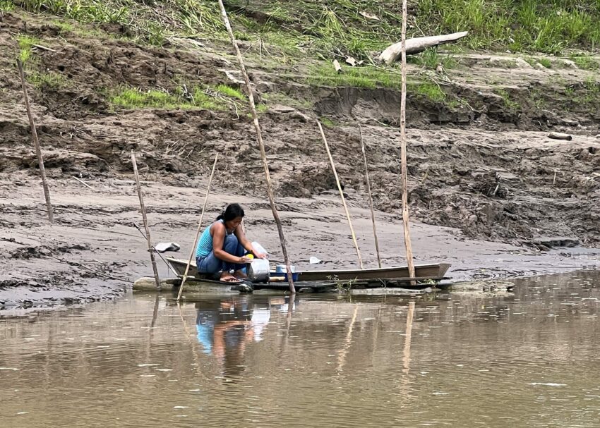 A woman washing cookware in the Amazon River in Colombia.