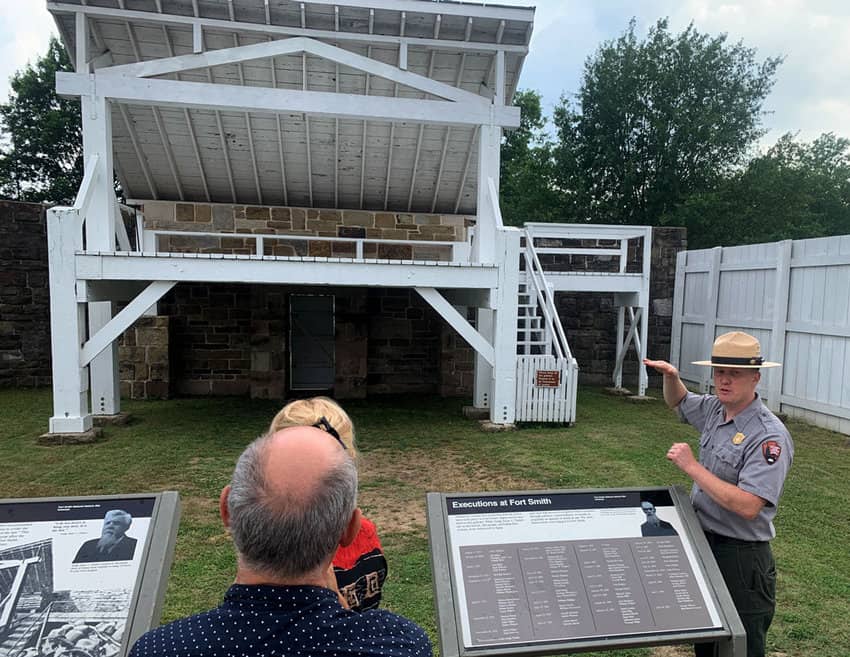 U.S. Park Ranger Cody Faber stands before a replica of the Fort Smith gallows, telling visitors stories about some of the outlaws who met their fate at the end of a rope and some of the innocent people who did as well. (Photo by Mark Stachiew)