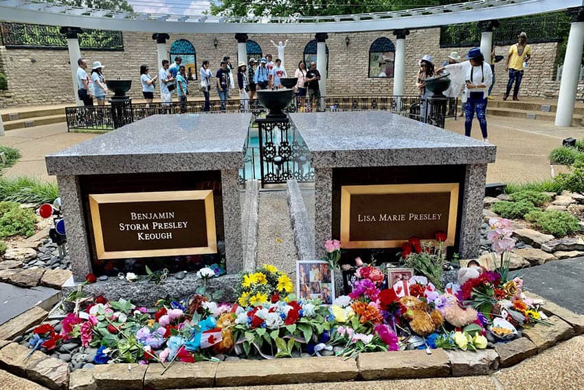 Graves of Lisa Marie and her son are near the grave of Elvis where visitors are standing at Graceland.